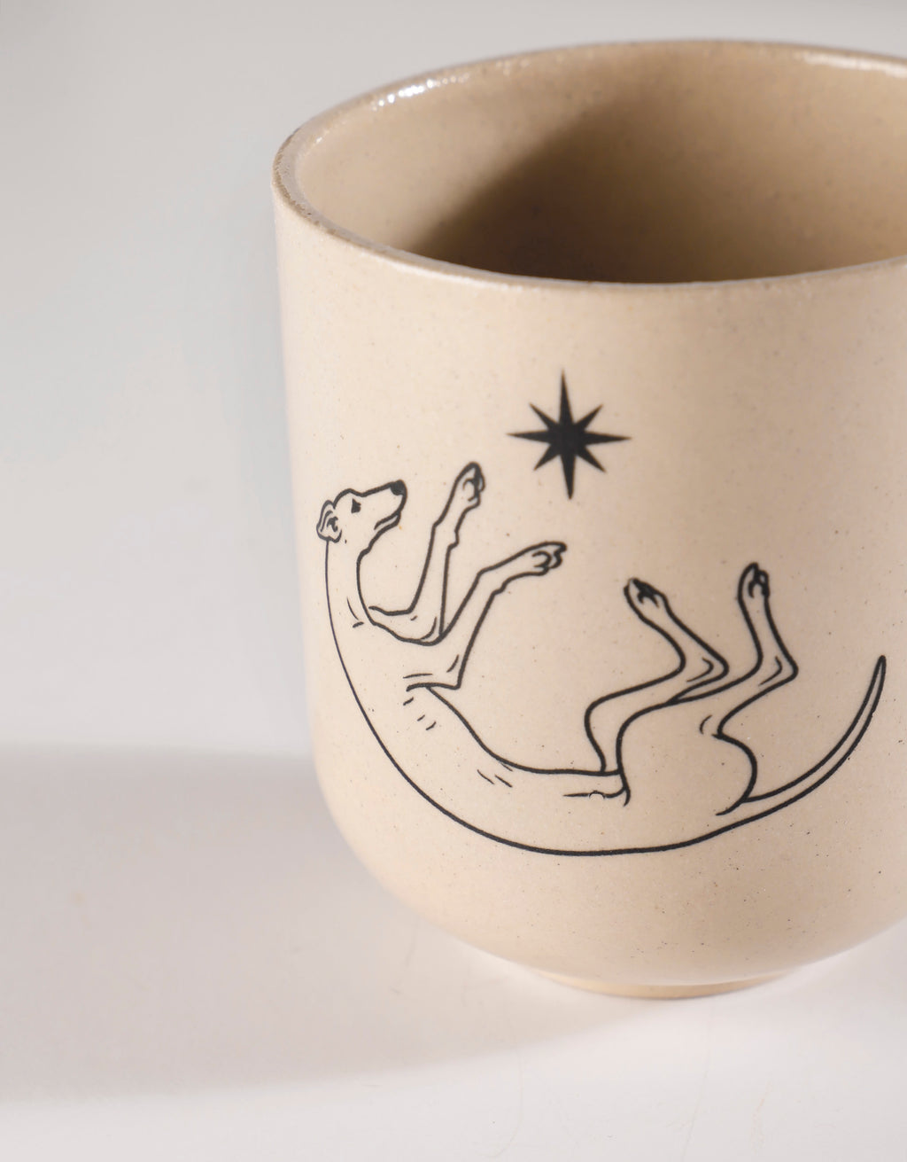 Handmade Black Roaching Greyhound Playing with a Star Ceramic Stoneware Handleless Cup
